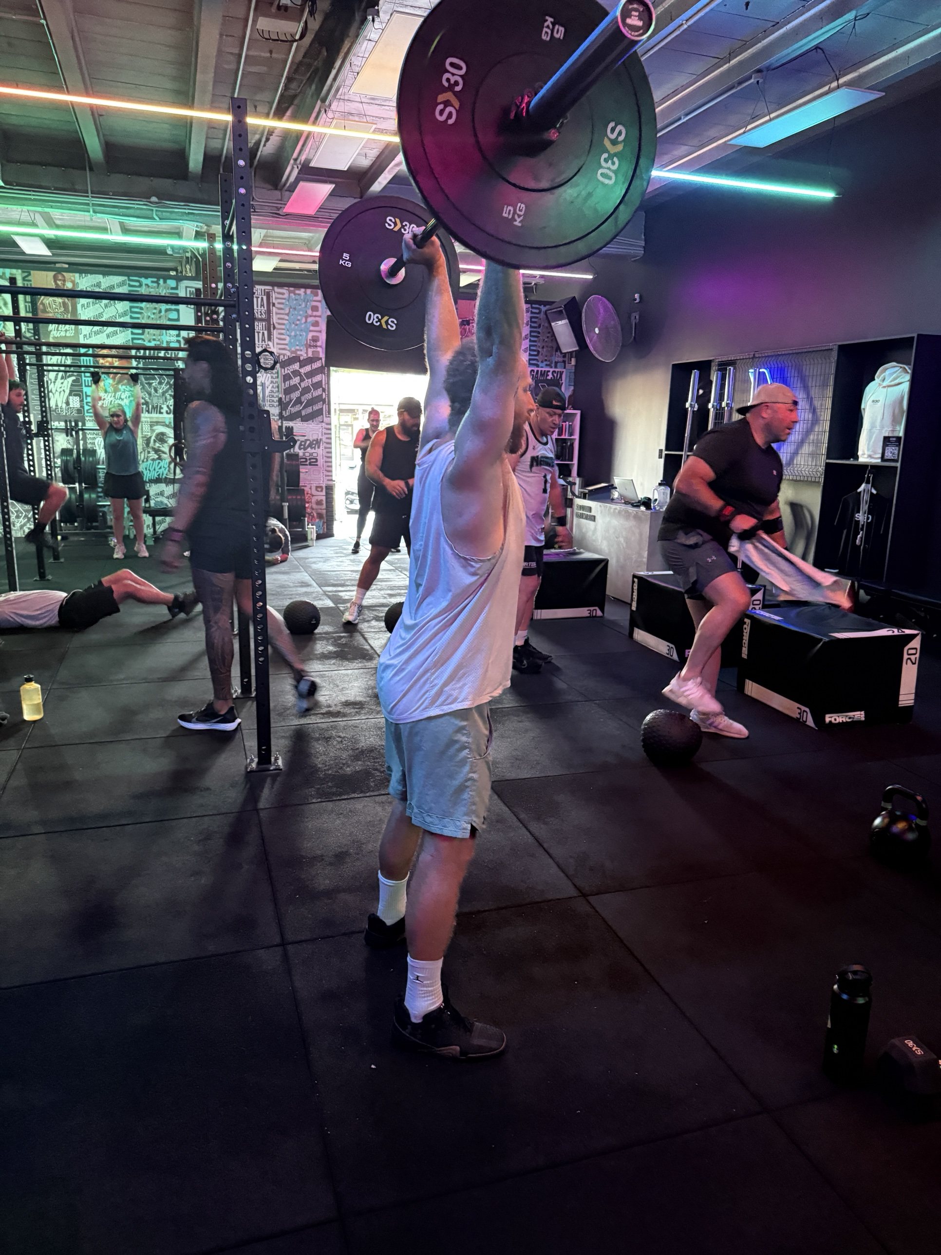 A member holding a barbell overhead