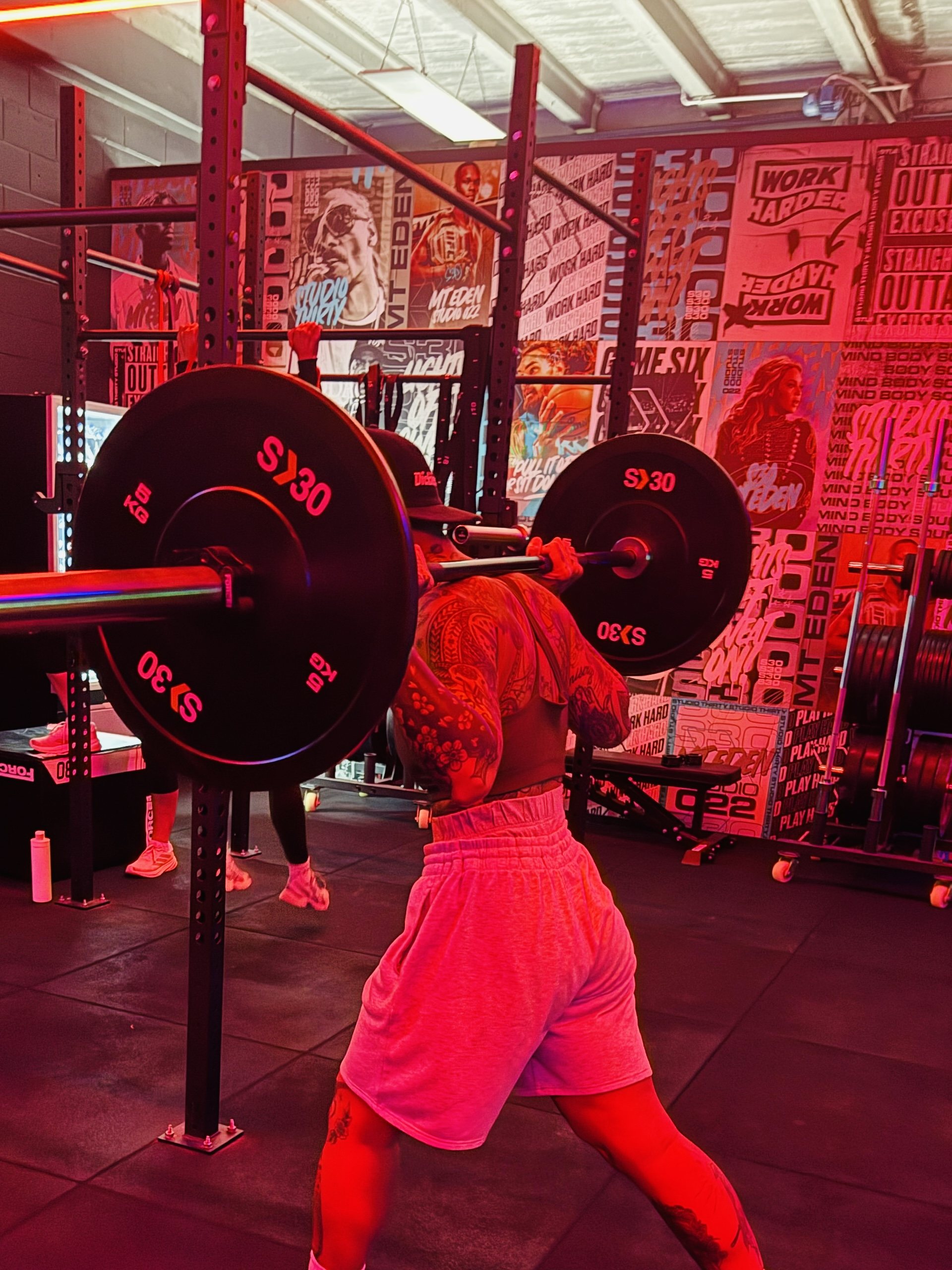 A member squatting a loaded barbell in the studio